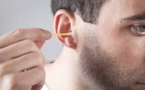 Man clean his ear using cotton bud 300x187