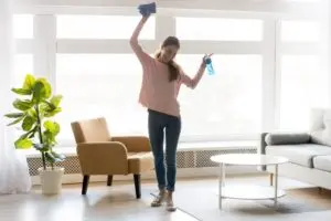 cheerful woman makes house cleaning holding rag spray bottle picture id 300x200