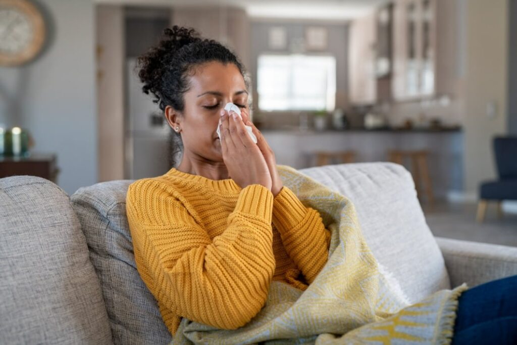 cold sick african woman blowing nose picture id